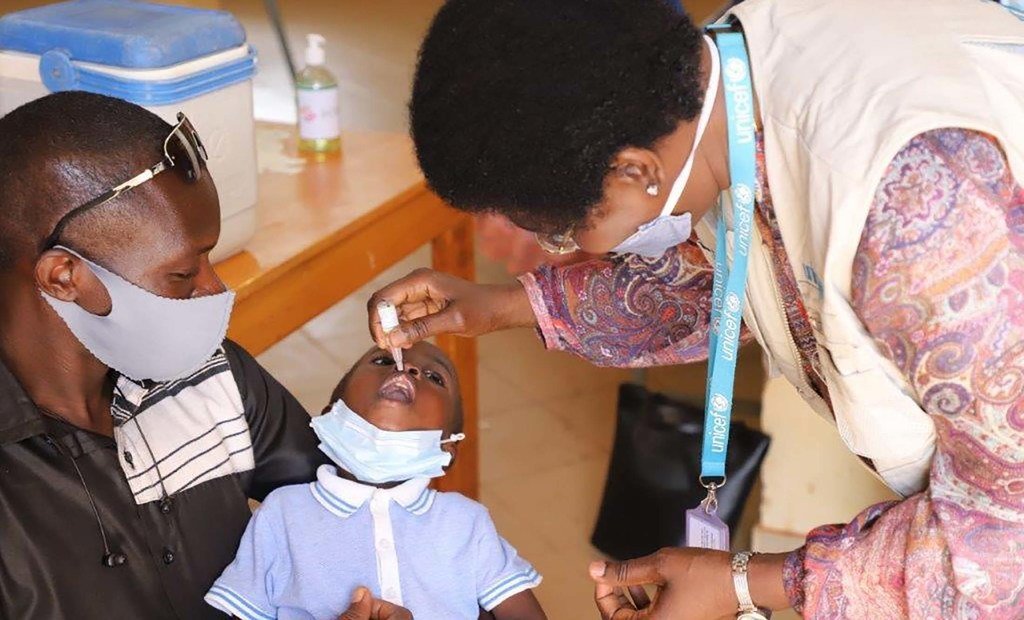 health worker administering polio vaccine to a child in Burkina Faso