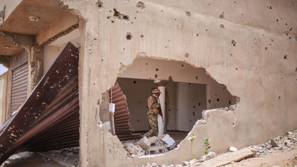 A fighter from the Front de Libération de l'Azawad (FLA) patrols a damaged building in Kidal on May 9, 2026.