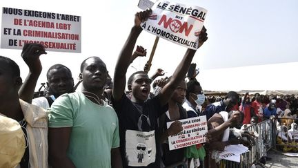 Protesters holding signs in Dakar on February 20, 2022, calling for stricter penalties against homosexuality