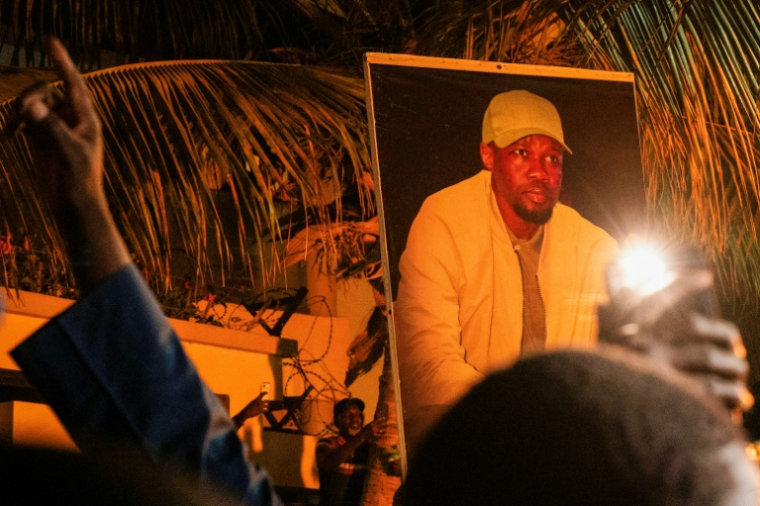 Supporters hold up Ousmane Sonko’s portrait during a spontaneous rally in Dakar