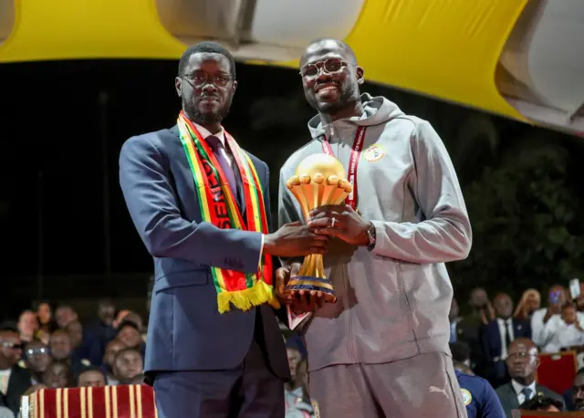 Senegalese President Bassirou Diomaye Faye and captain Khalidou Koulibaly holding the CAN 2025 trophy together
