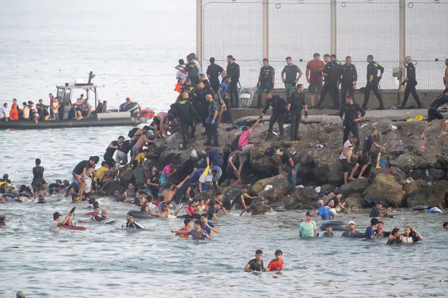 Migrants crossing the border into Ceuta